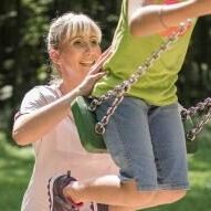 Kundin und Mitarbeiterin Jessica Mayer-Durke, schubst Kind auf Schaukel an