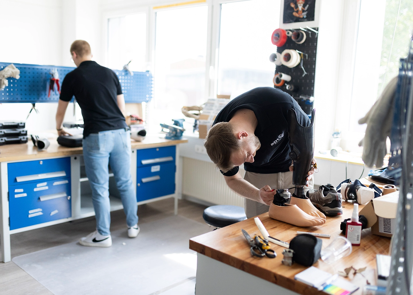 Zwei Orthopädietechniker arbeiten in der Werkstatt bei APT Prothesen