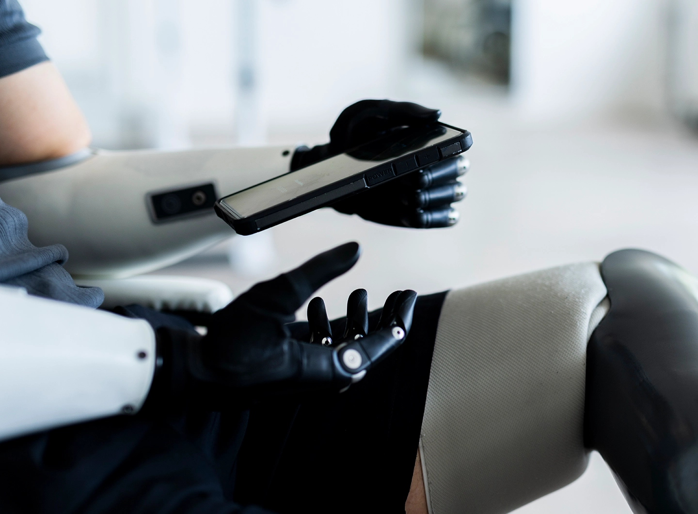 Person mit zwei Armprothesen hält Handy in der Prothesenhand