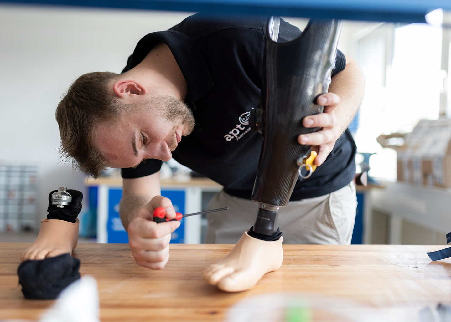 Orthopädietechniker schraubt an einer Unterschenkelprothese in Werkstatt