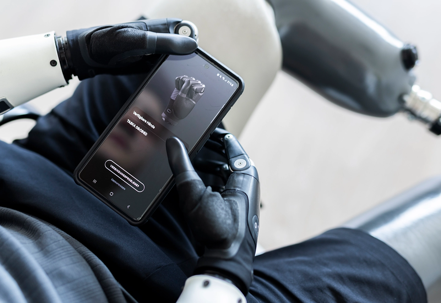 Aufnahme über der Schulter von der Bedienung einer App zur Steuerung von Handprothesen und Passteilen von Armprothesen