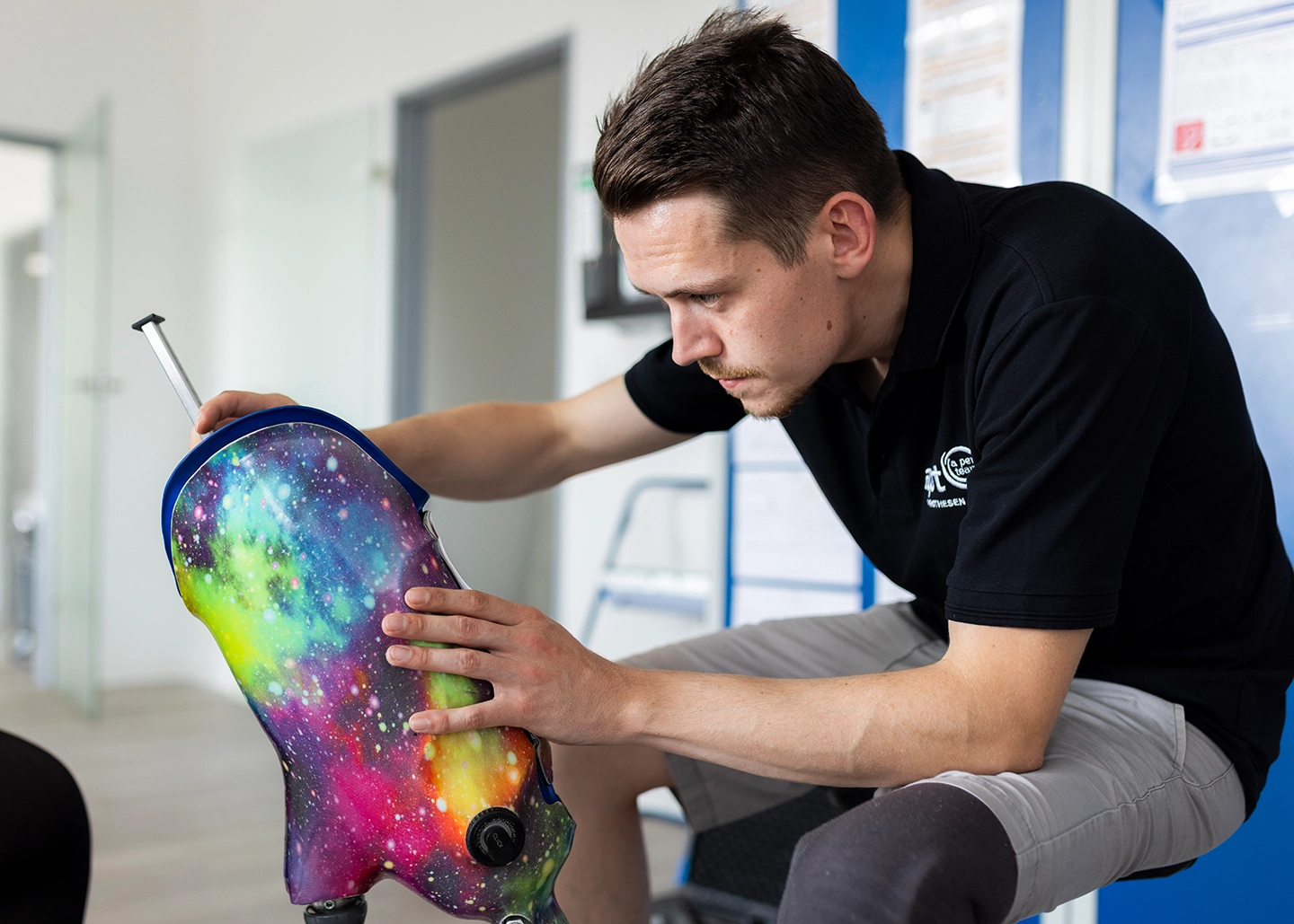 Orthopädietechniker arbeitet an dem Schaft einer bunten Beinprothese