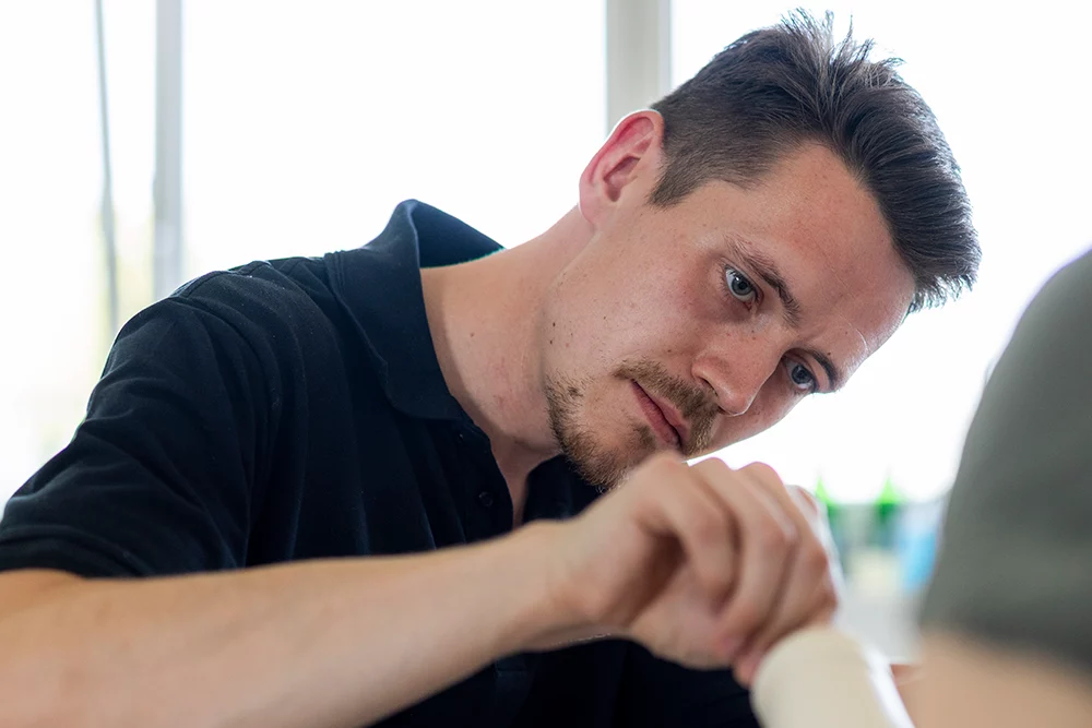 Filialleiter Benedikt Felderhoff schaut auf Prothese bei Versorgung in seiner Filiale Bochum