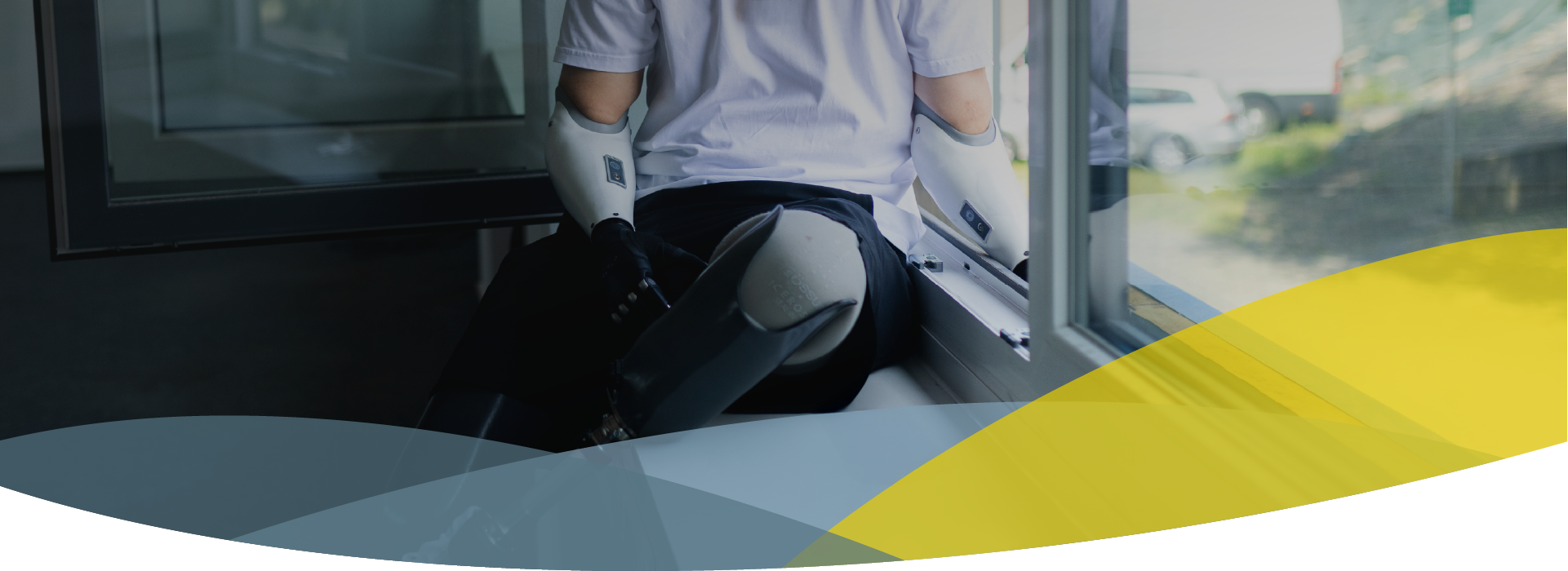 Headerbild für Startseite, Person sitzt auf Fensterbank und lehnt sich aus dem Fenster, trägt zwei Beinprothesen und zwei Armprothesen