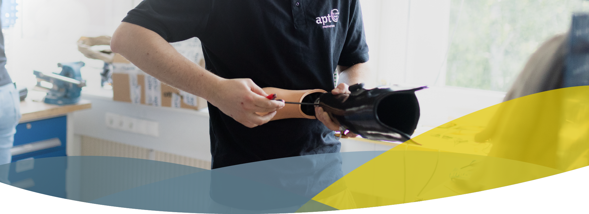 Headerbild für Karriere, Techniker schraubt in der Werkstatt bei APT Prothesen an einer Beinprothese