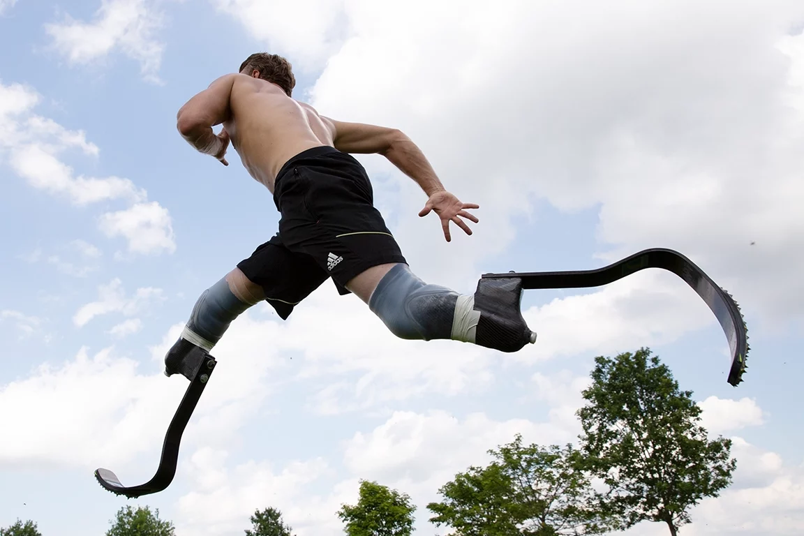 Mann springt mit zwei Sportprothesen