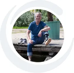 Kundenstimme von Martin. Kunde bei APT Westerwald und Träger einer Beinprothese. Er sitzt auf dem Bild am Wasser.